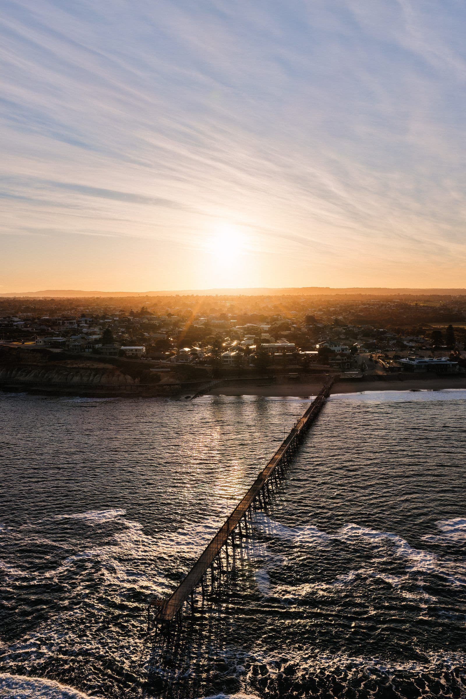 Sunrise over a coastal jetty stretching into the ocean