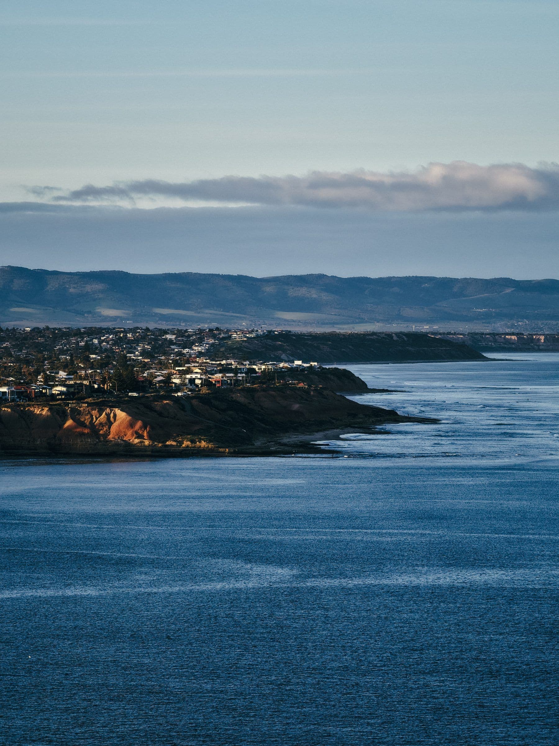 Coastal town on a bluff overlooking a wide bay at blue hour