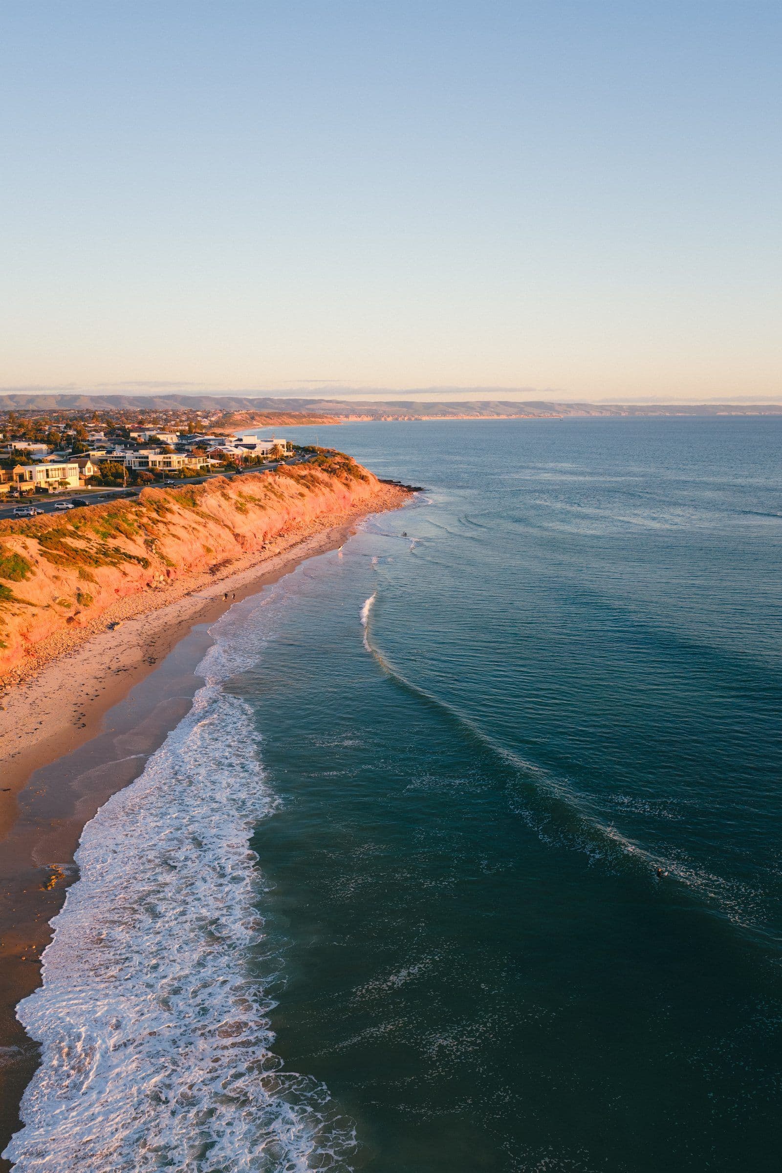 Sunlit red cliffs meeting turquoise water