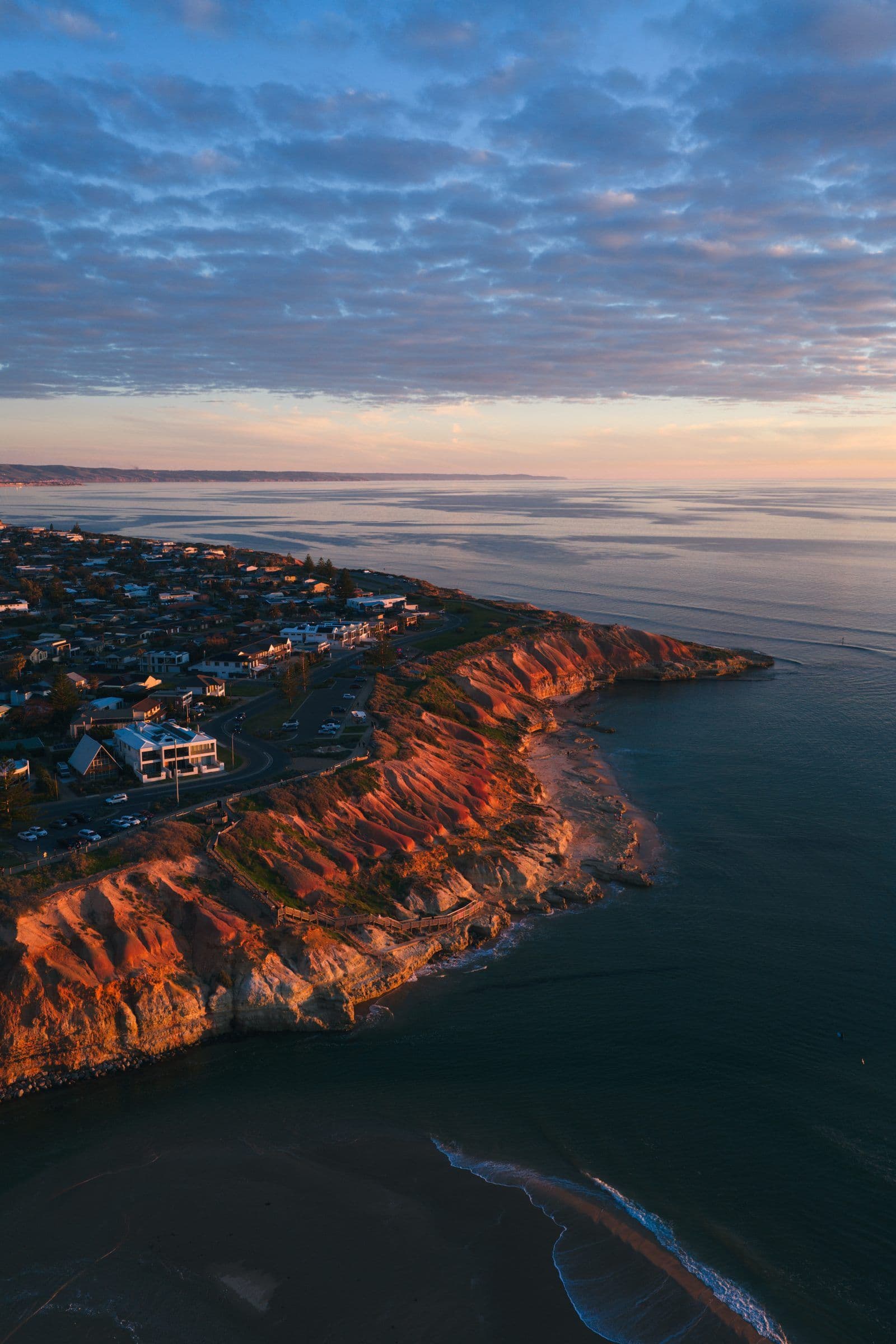 Dramatic golden-hour light over cliffs above a coastal town