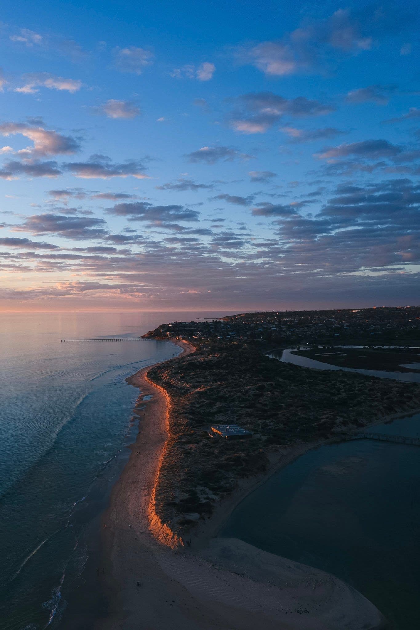 Blue hour over a jetty and dune-lined shoreline