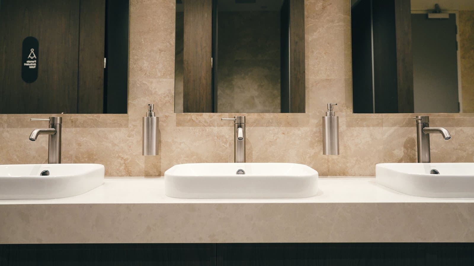 Row of modern sink basins beneath mirrors in a finished renovation